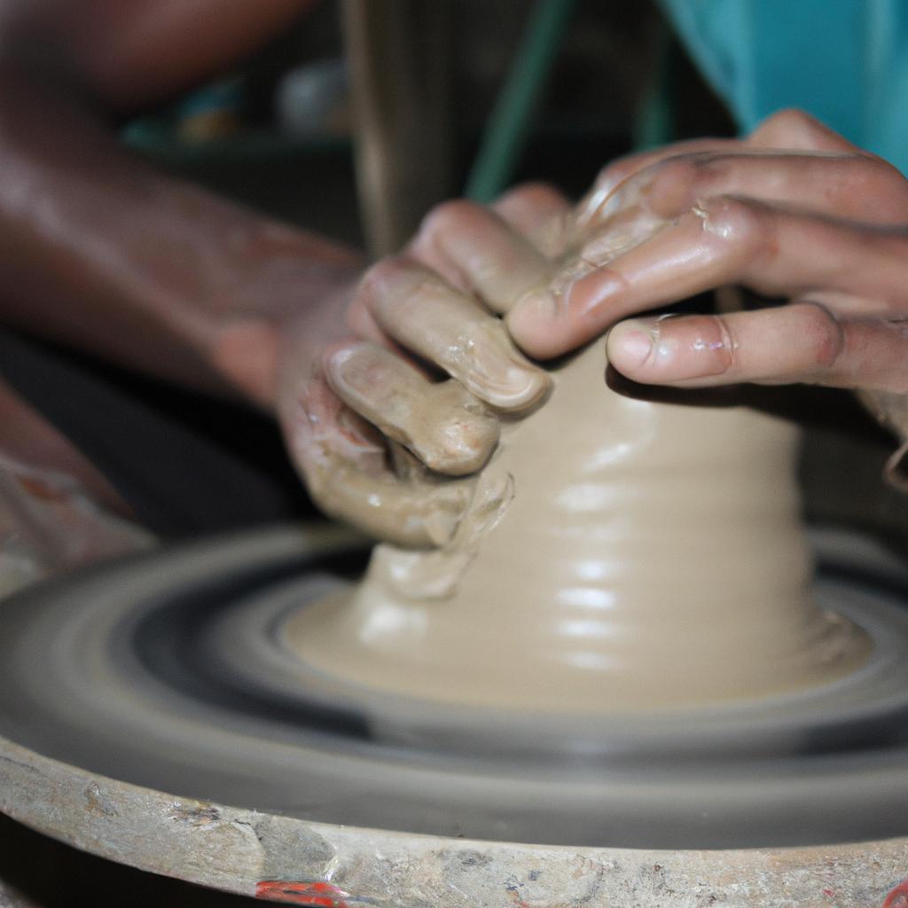 Person molding clay on wheel