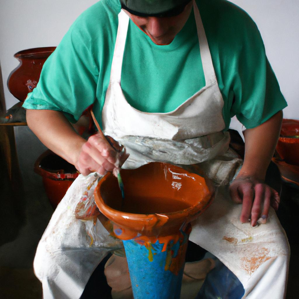 Potter applying glaze to pottery