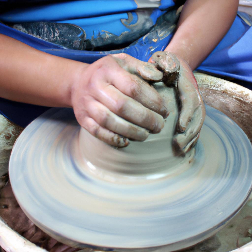 Person molding clay on pottery wheel