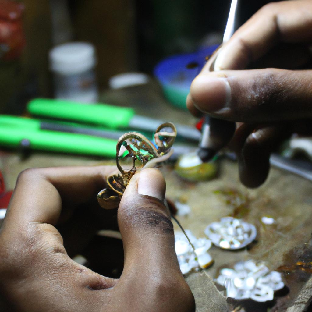 Person crafting intricate pendant designs